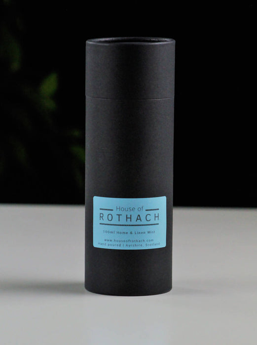 Matt black gift tube made with recycled cardboard. Blue label on front and House of Rothach sticker on lid.